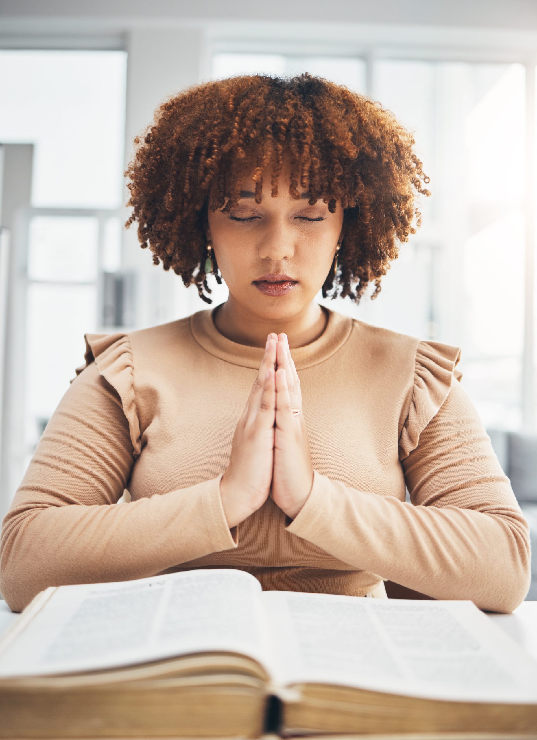 Woman Praying Over An Open Bible